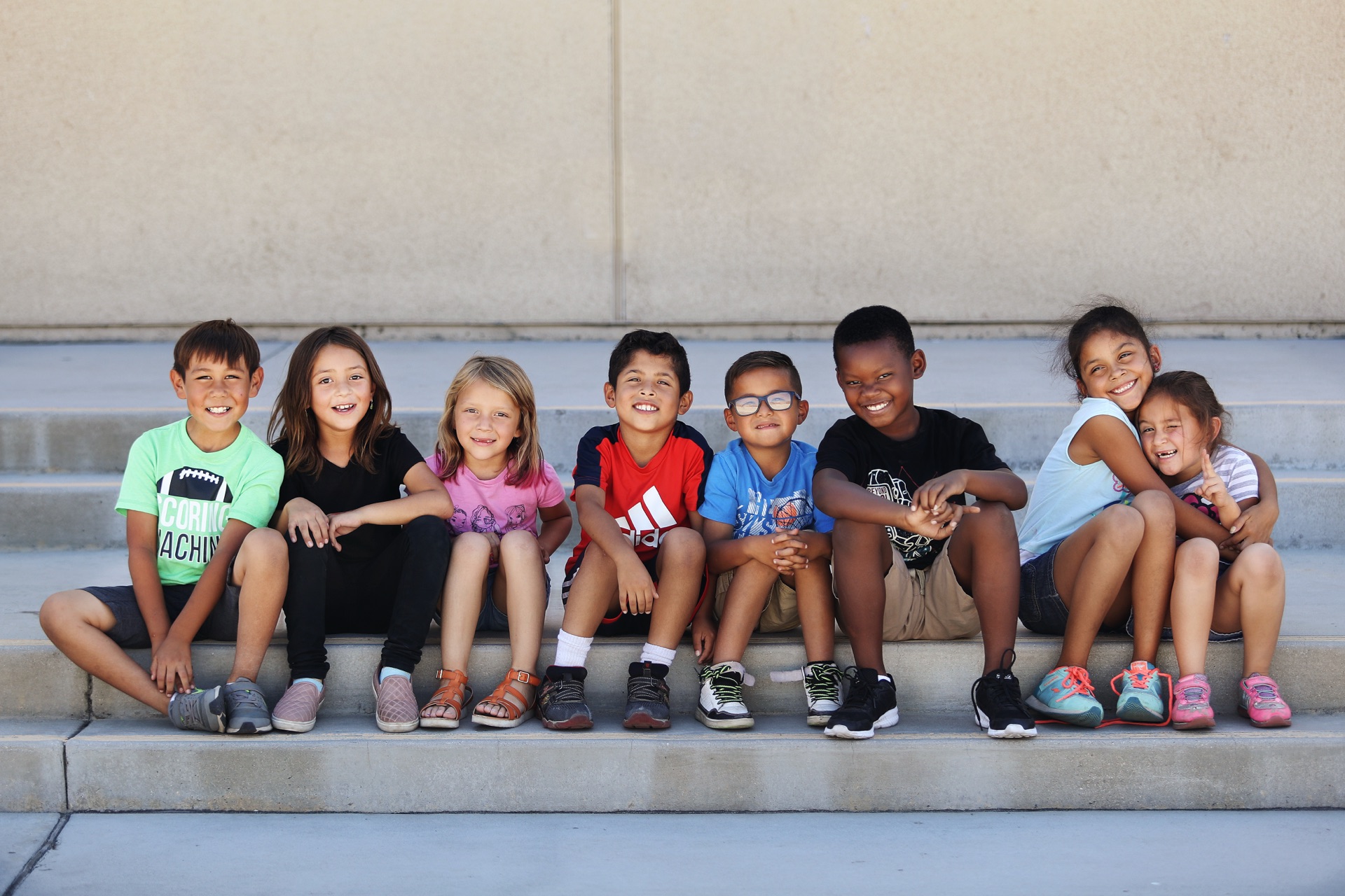 Students sitting on school steps smiling